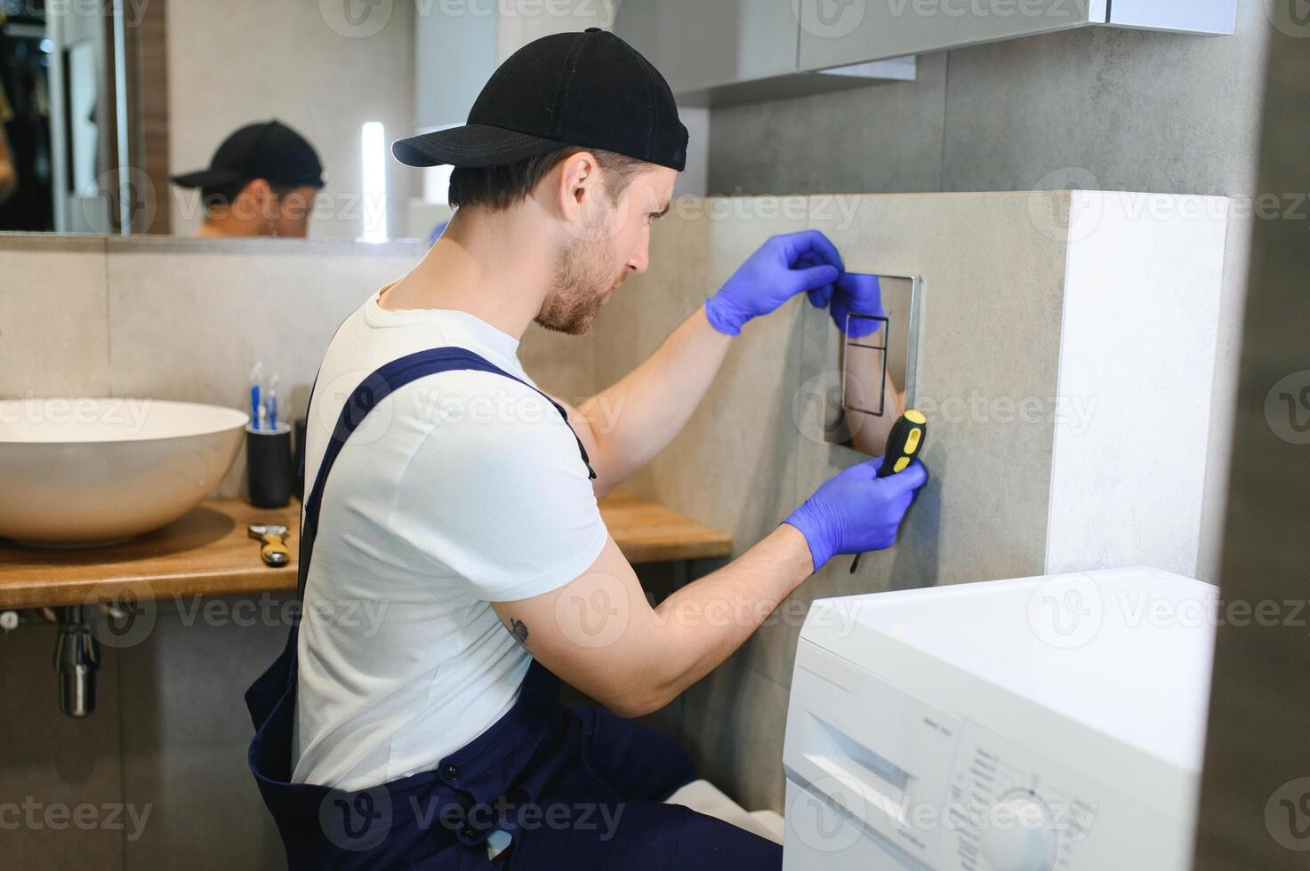 Plumber installing toilet bowl in restroom, work in bathroom. photo