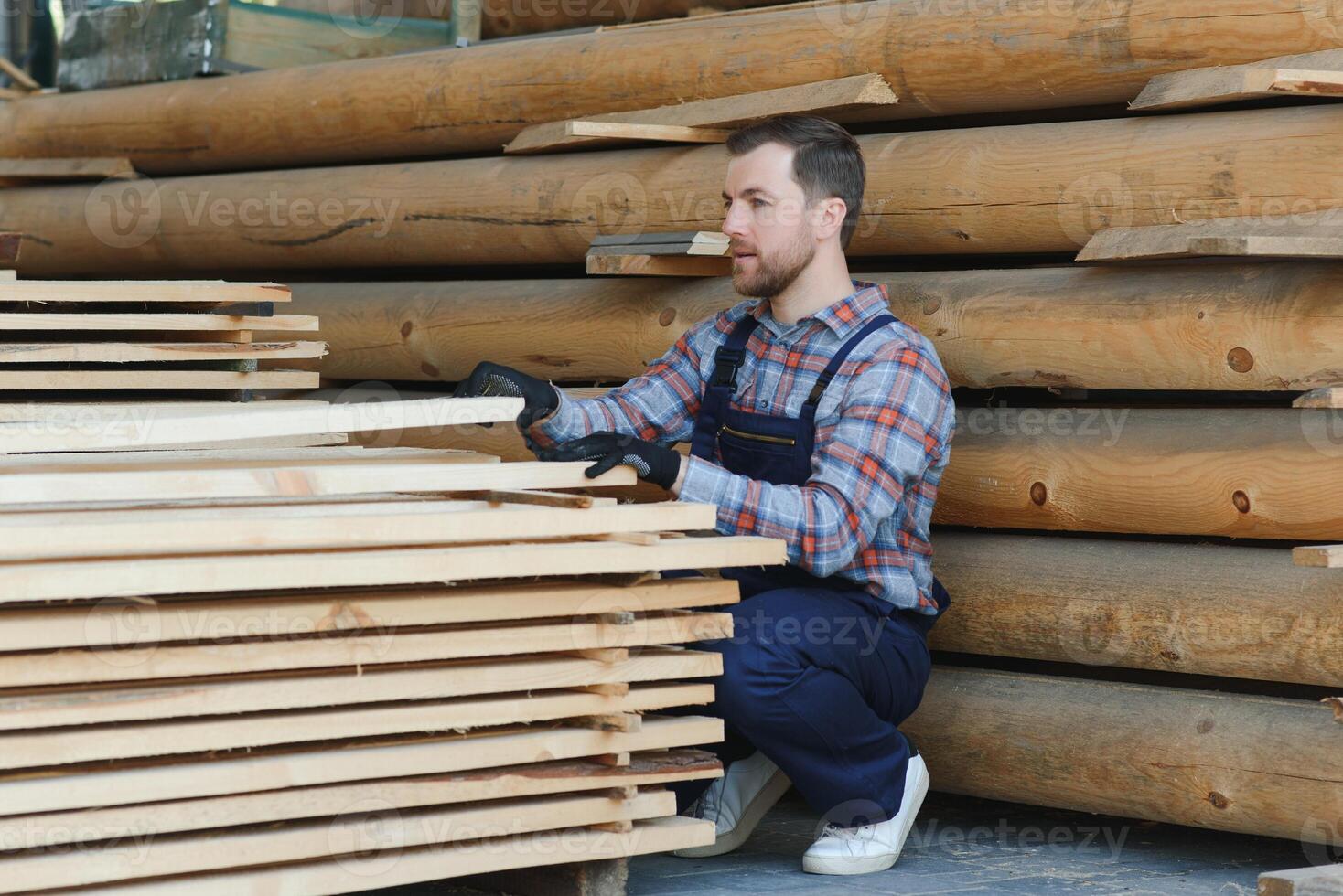 Joiner in uniform check boards on timber mill photo