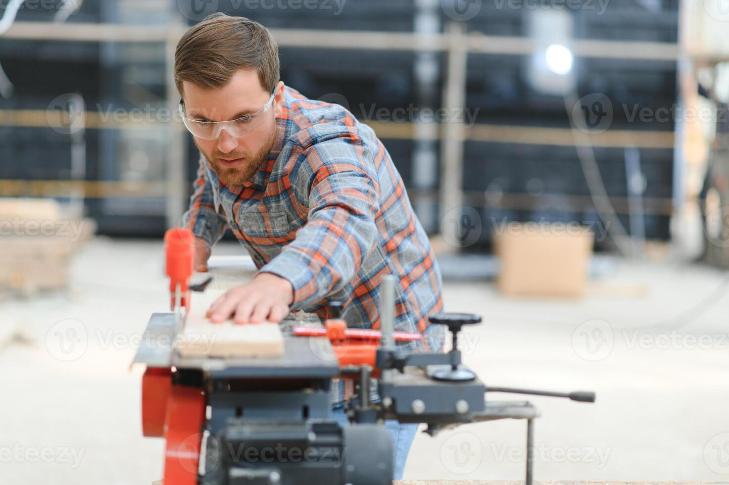 Skilled cabinet maker cutting wood board with electric circular saw at woodworking sawmill. Professional cabinet maker use circular saw at sawmill factory. Wooden furniture production. Joinery photo
