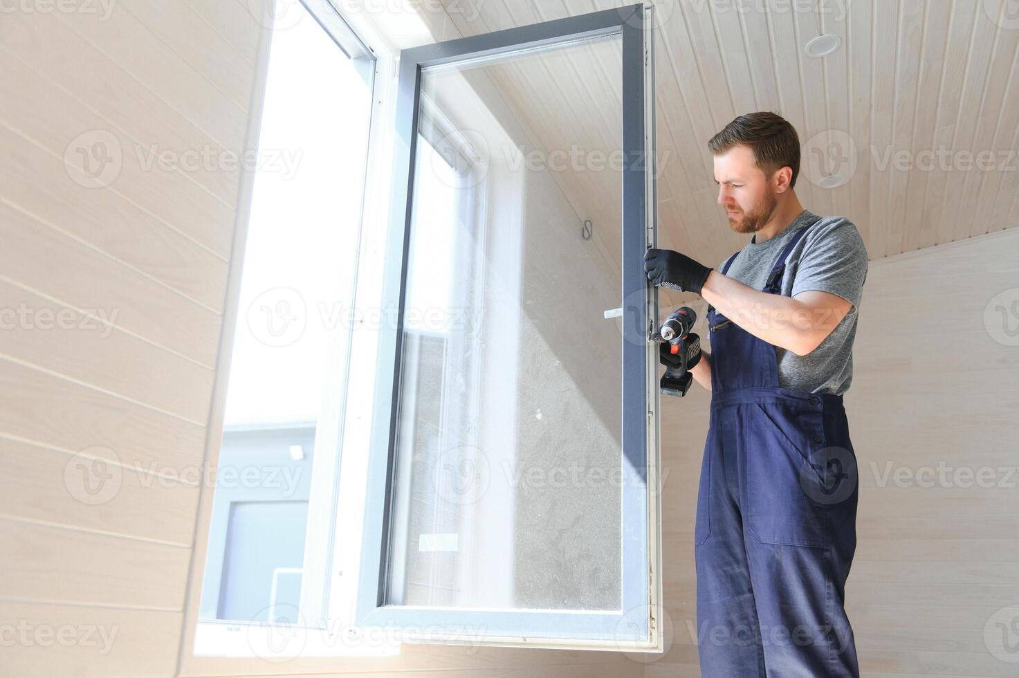 Construction worker installing new window in house photo