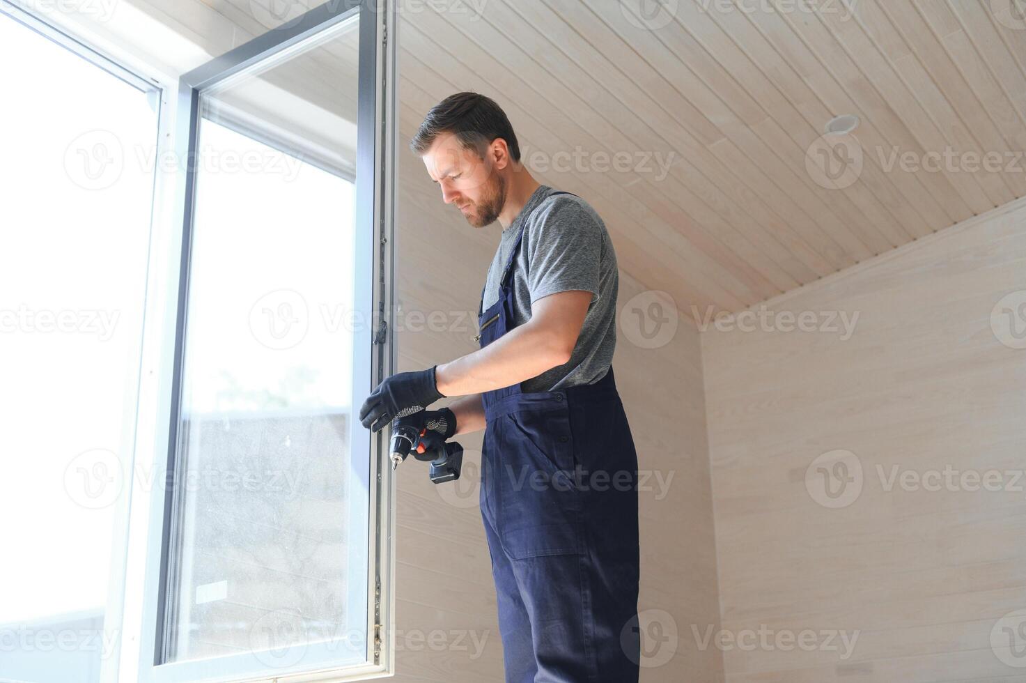 A worker installs windows in a new modular home. The concept of a new home. photo