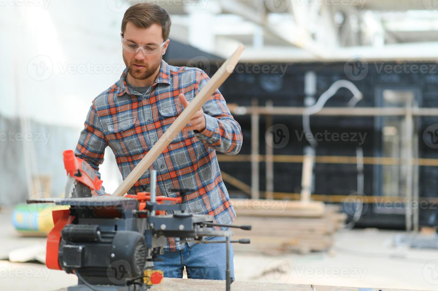 Professional carpenter using sawing machine for cutting wooden board at sawmill. Skilled cabinet maker working with electric circular saw at woodworking workshop. photo