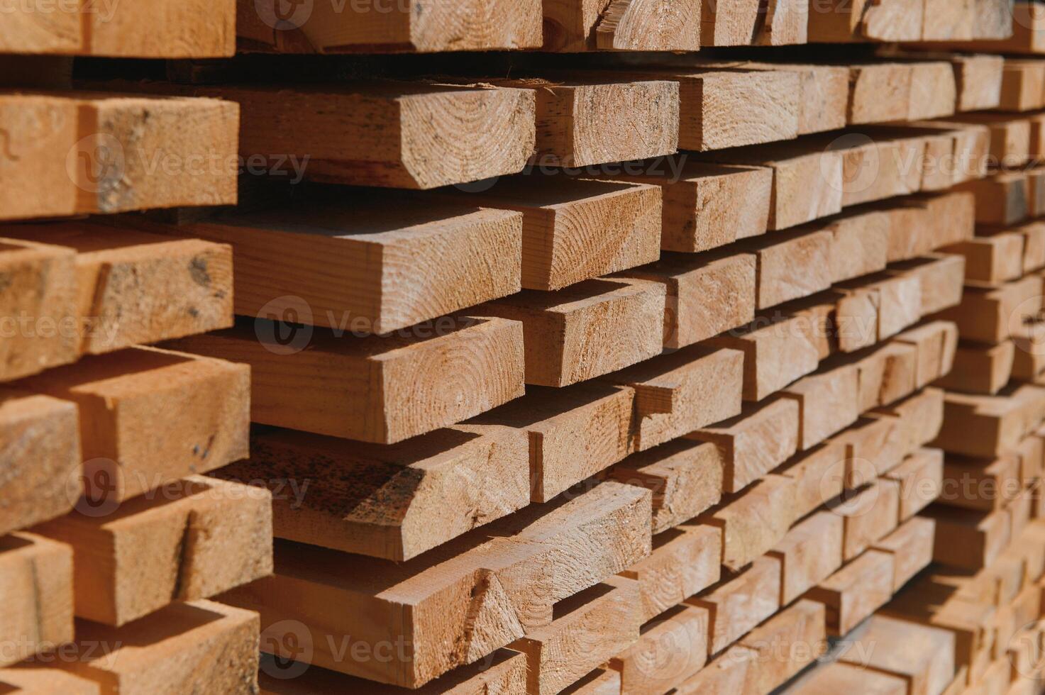 Stack of lumber of a wooden board from a tree, close-up, background. Wooden boards at the sawmill, carpentry workshop. Sawing and air drying of wood. Woodworking industry. Wooden boards photo
