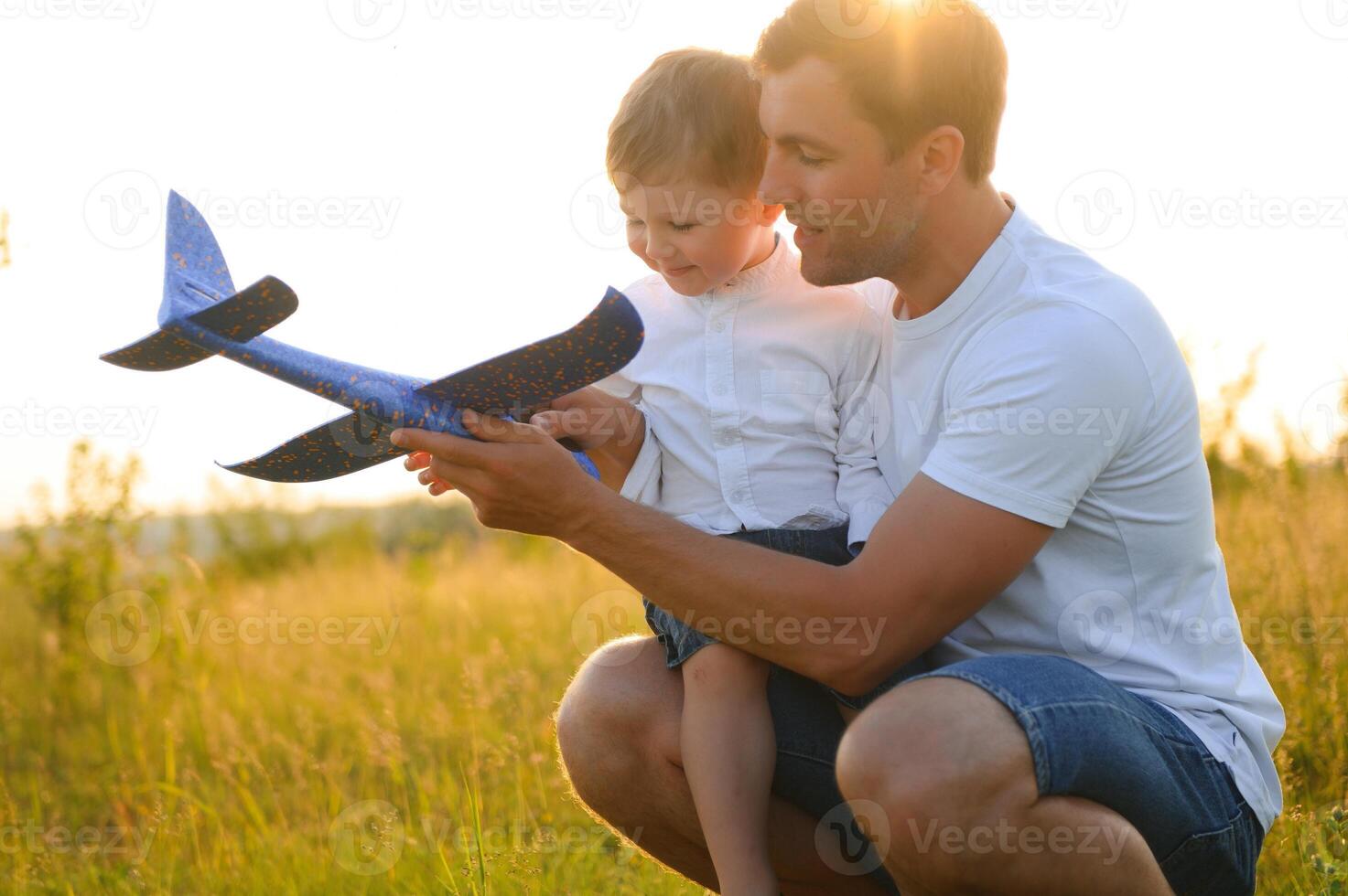 Dad with his son at sunset in nature. A father plays with toy airplanes with his son at sunset. father's day photo