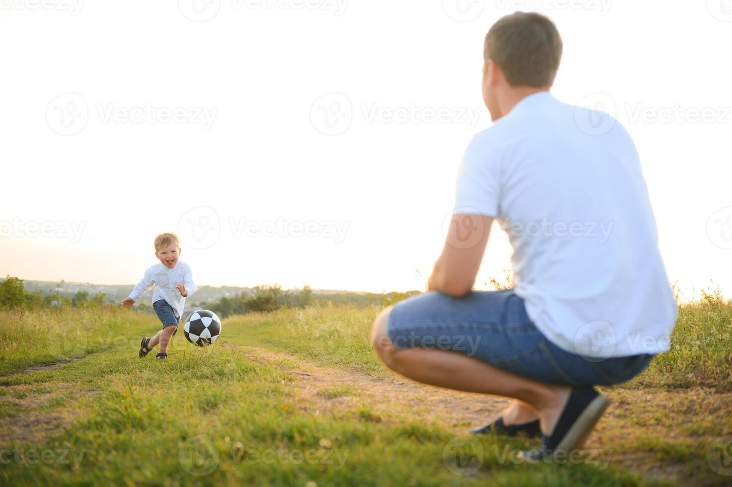 Young father with his little son playing football, father's day. photo