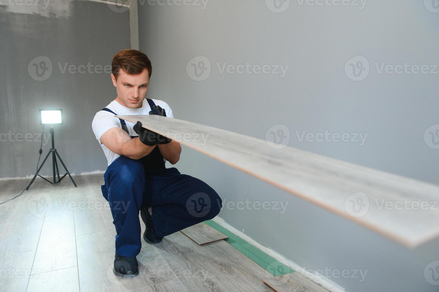 Man installing new laminated wooden floor photo