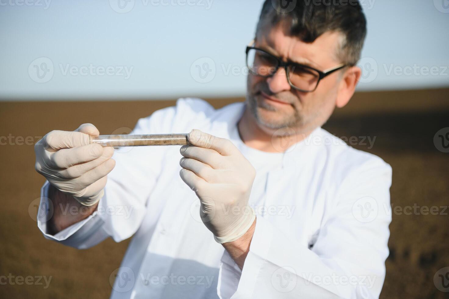Soil Sampling. Agronomist taking sample with soil probe sampler. Environmental protection, organic soil certification, research photo