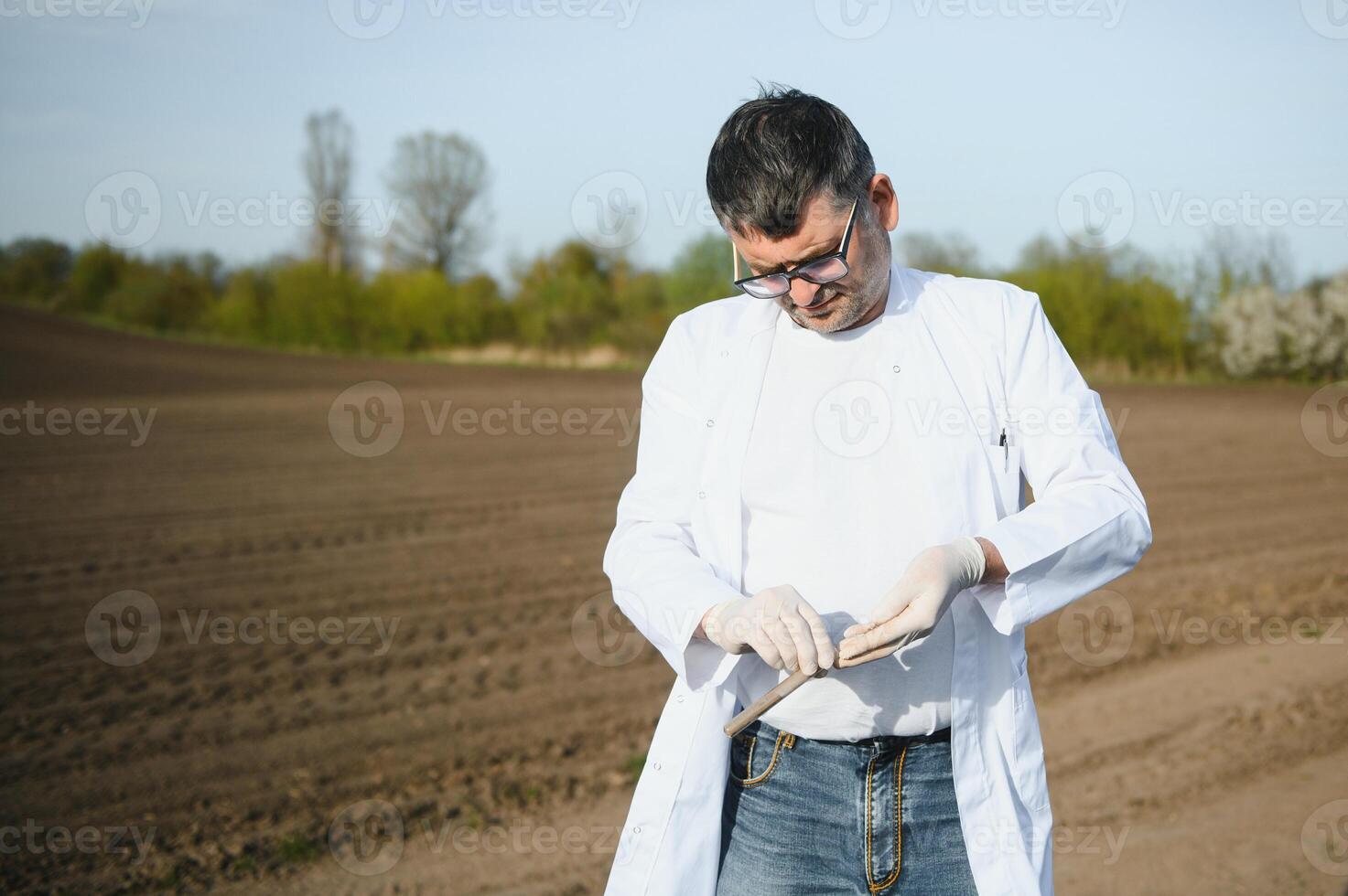 Soil Sampling. Agronomist taking sample with soil probe sampler. Environmental protection, organic soil certification, research photo