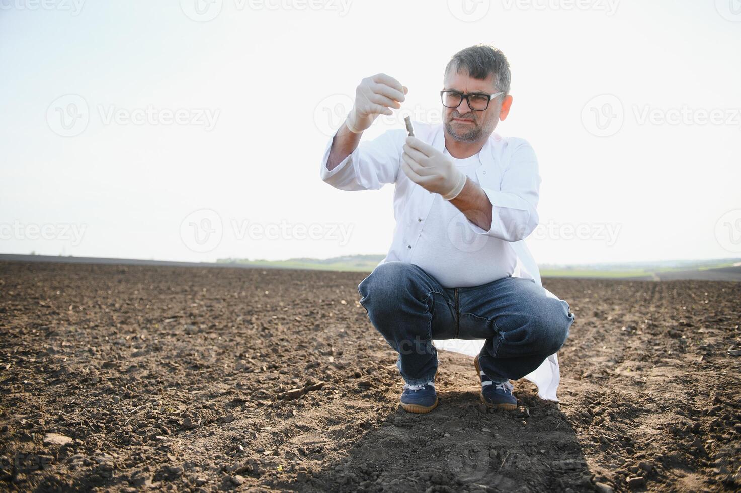 Soil Sampling. Agronomist taking sample with soil probe sampler. Environmental protection, organic soil certification, research photo