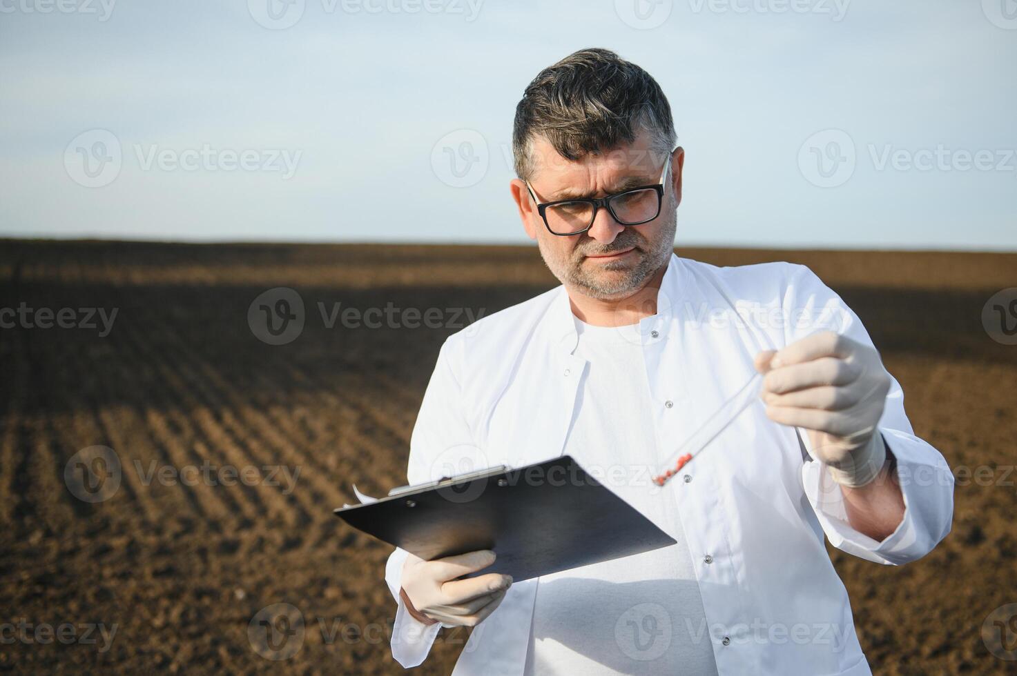 Soil Sampling. Agronomist taking sample with soil probe sampler. Environmental protection, organic soil certification, research photo