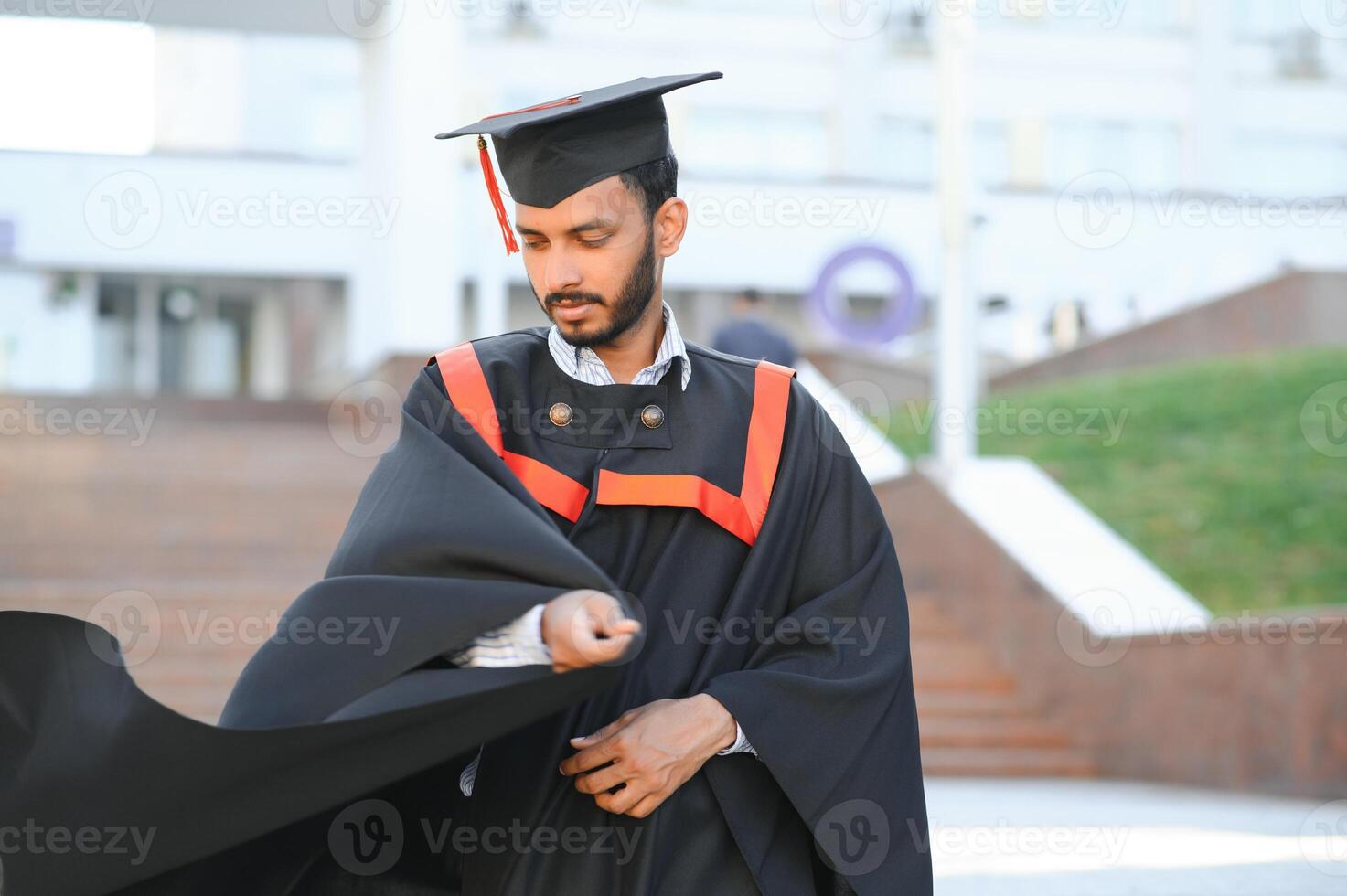 portrait of successful indian student in graduation gown. photo