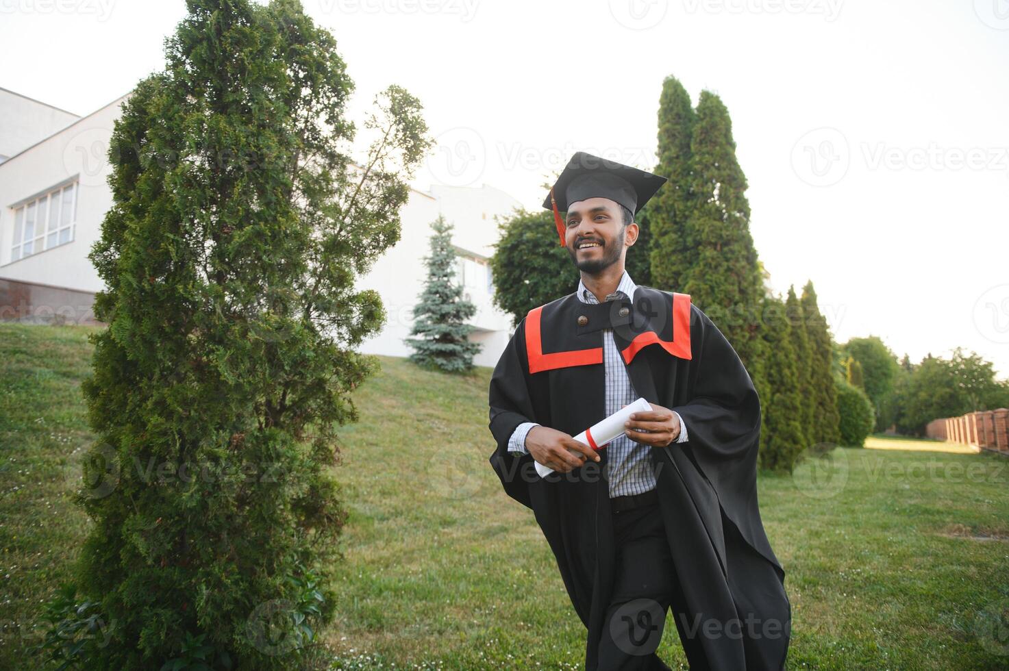 portrait of successful indian student in graduation gown. photo