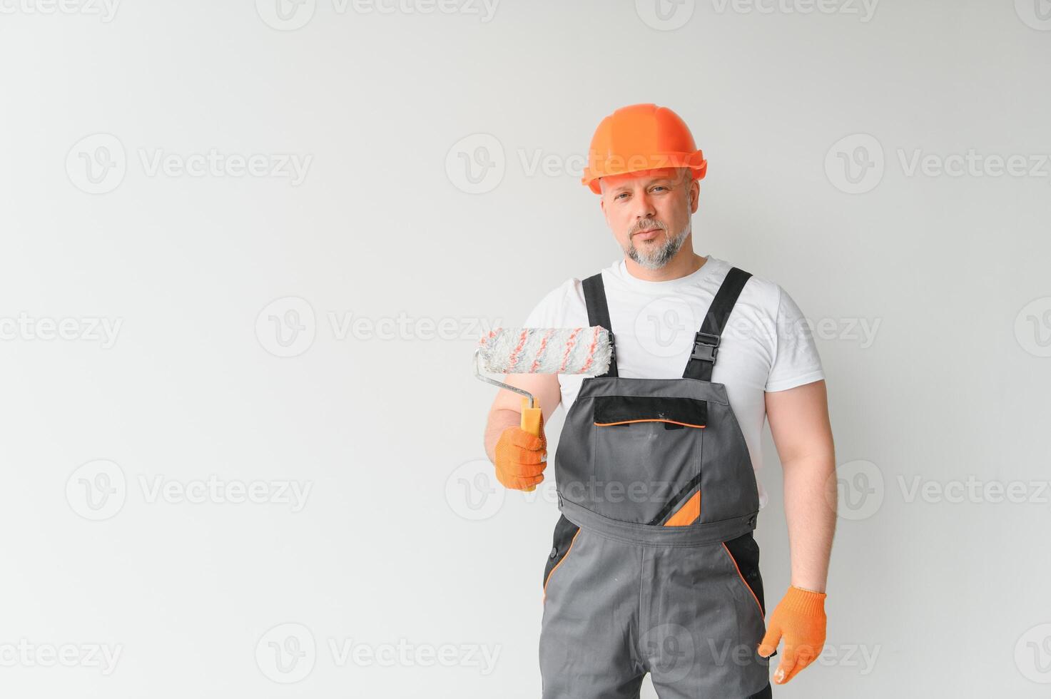 Painter using a paint roller and painting a wall isolated on white background. photo