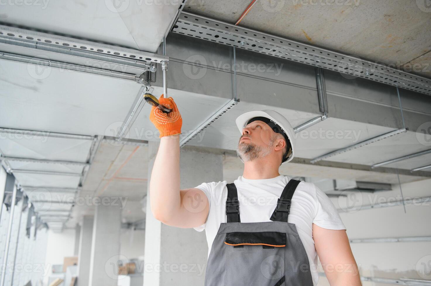 Man repairman. Master near ventilation pipes. Installation of ventilation for buildings. Man repairman with back to camera. Metal ventilation pipes. photo