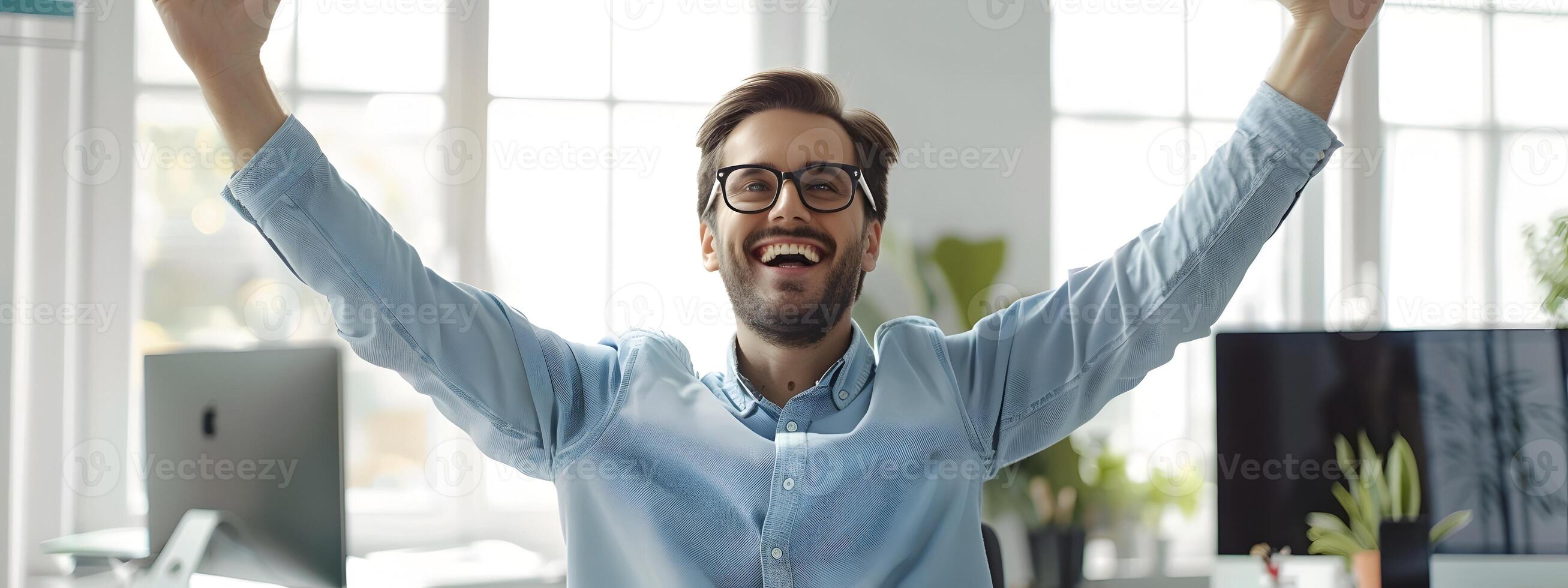 Enthusiastic Young Business Professional Celebrating Success at Office Desk photo