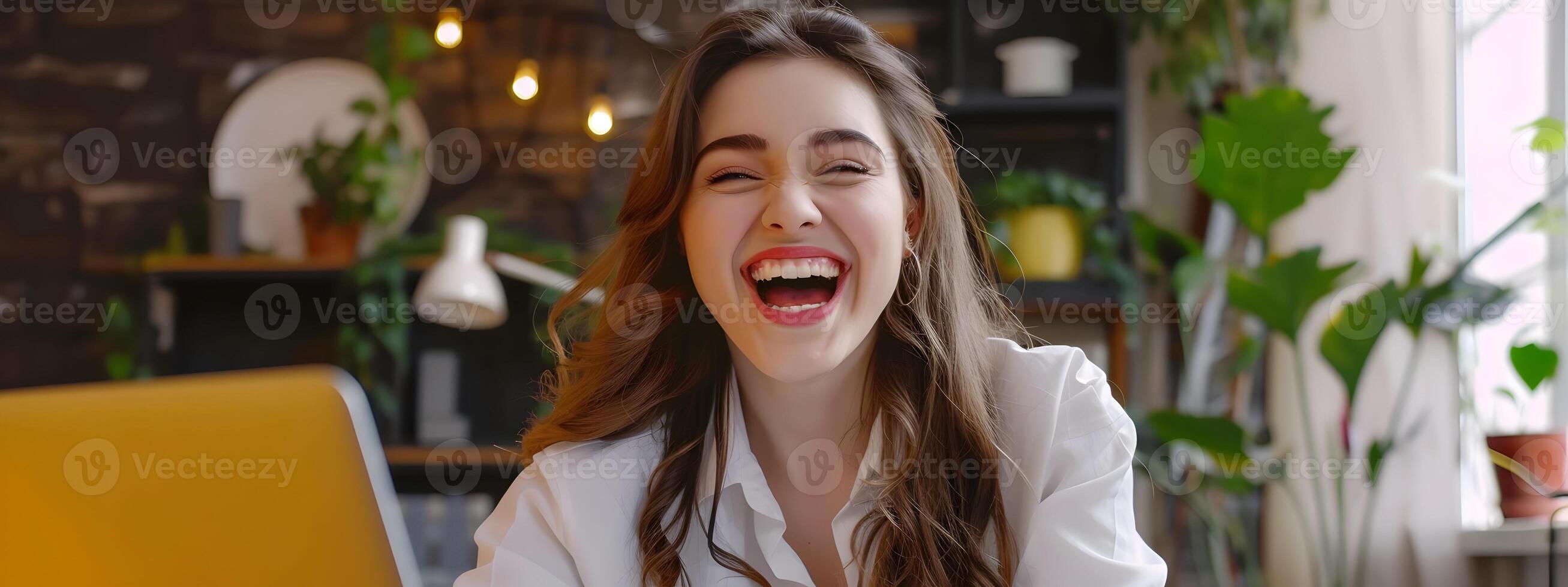 Joyful Young Marketing Consultant Beams with Enthusiasm and Confidence While Working on Laptop in Vibrant Office Setting photo