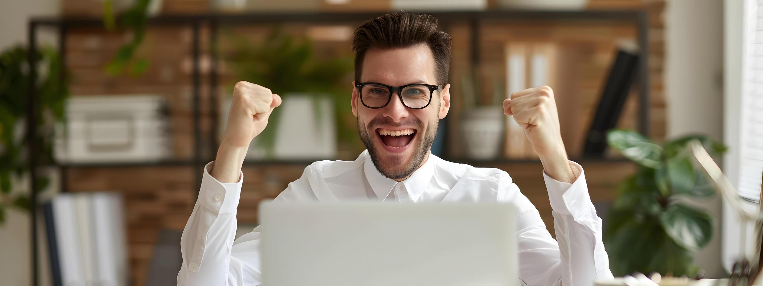 Joyful Young Businessman Celebrating Successful Completion of Accounting Tasks at His Desk photo