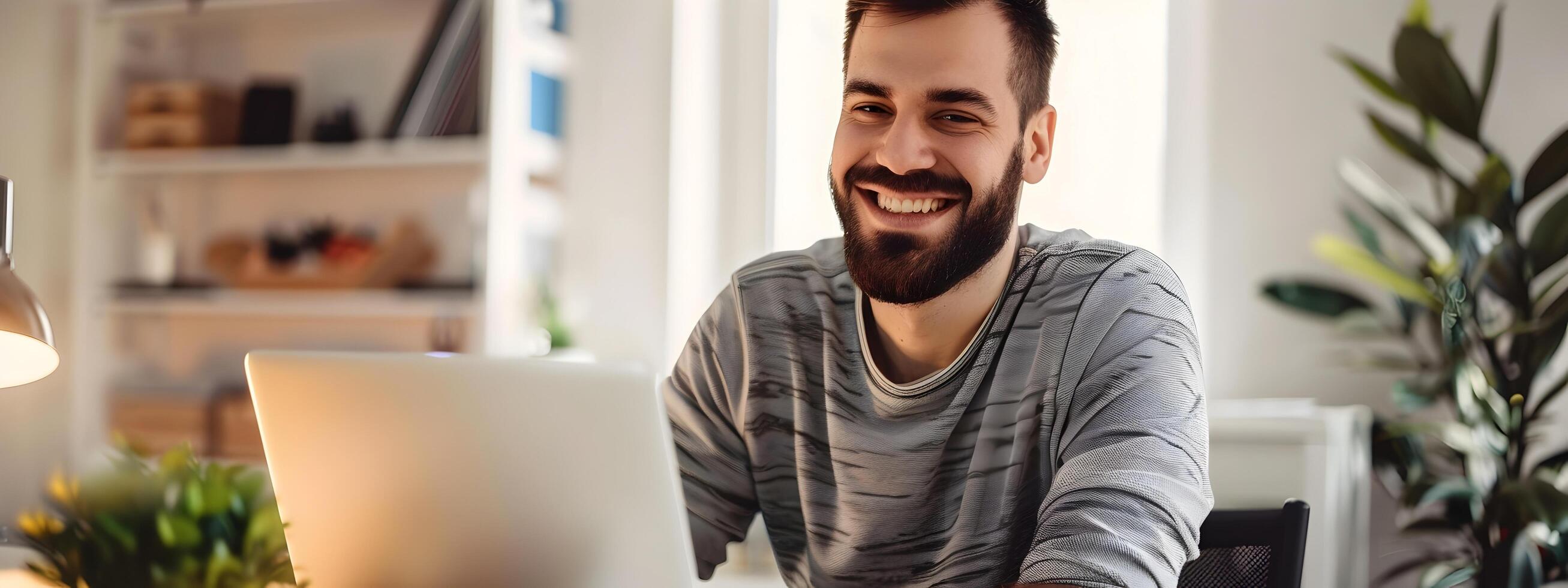 Smiling Young Web Developer Working Remotely on Laptop at Home Office photo