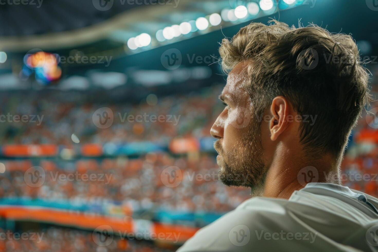 Soccer coach watching match at stadium with fans cheering photo