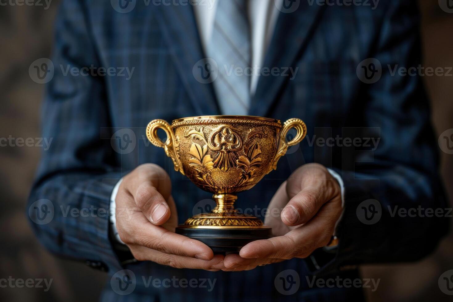 Closeup photo of a businessman holding a gold trophy cup, representing success and recognition in the corporate or sports realm