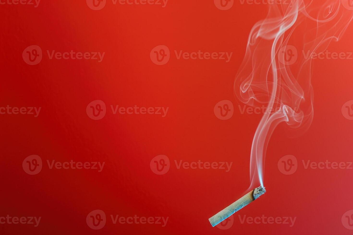 Cigarette emitting smoke against a red gradient background photo