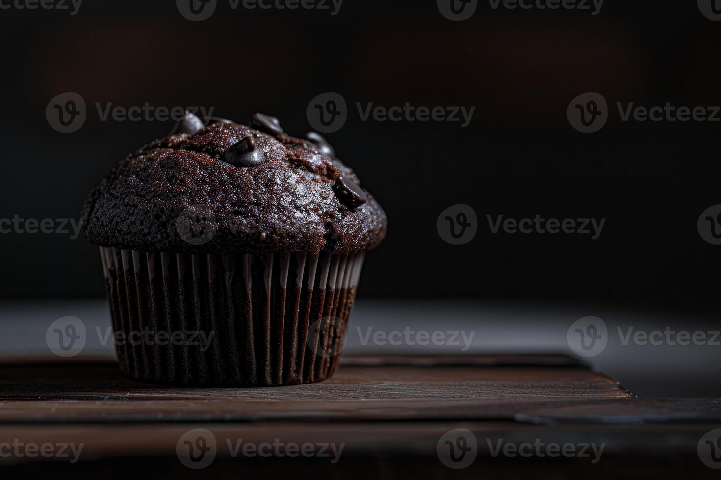 Meticulously shot image capturing a chocolate muffin against a dark backdrop, highlighting its texture and appeal photo