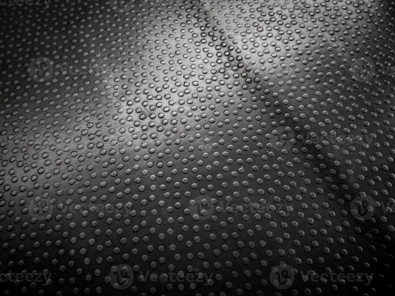 Formation of dots on black synthetic leather with a little dust in the middle photo