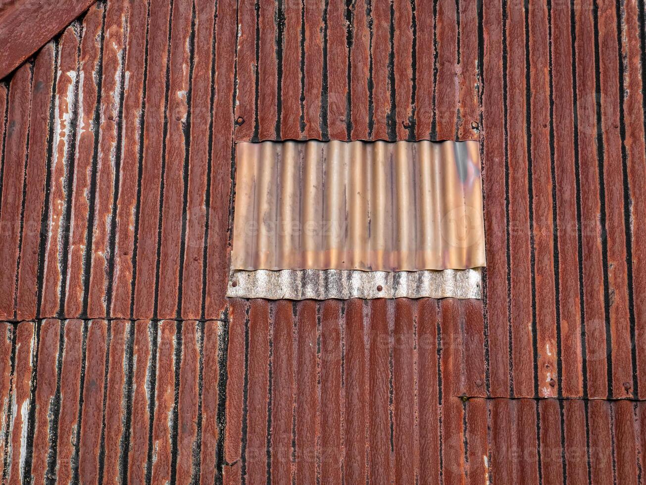 old and rusty zinc sheet roof with one block sheet turning white photo