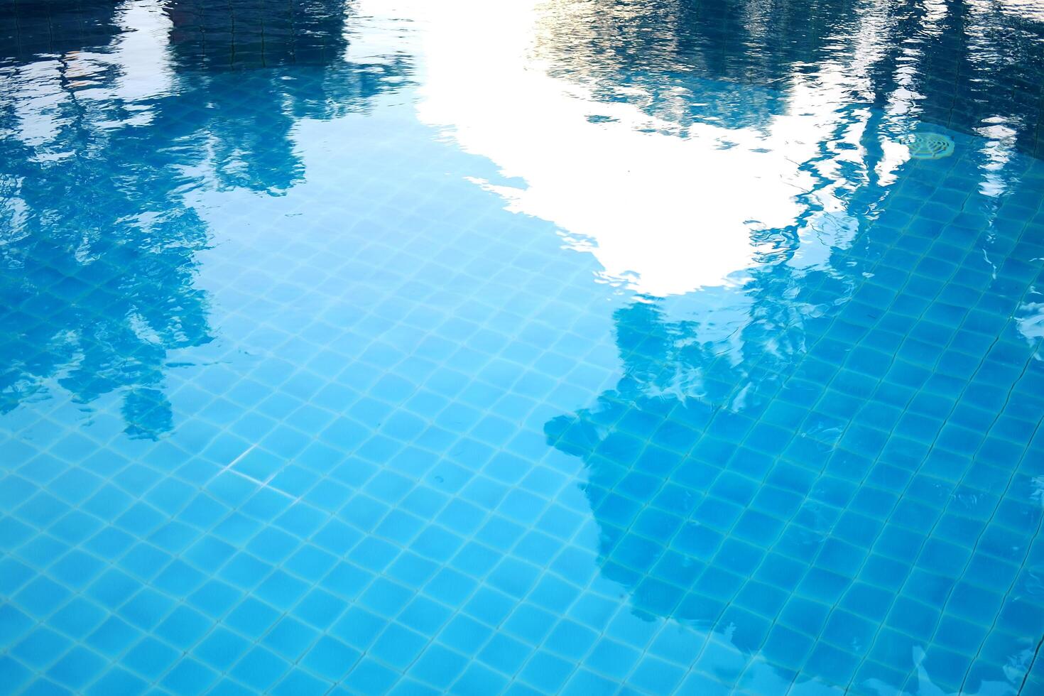 Blue water and ceramic tiles in swimming pool outdoor in garden of resort and hotel photo