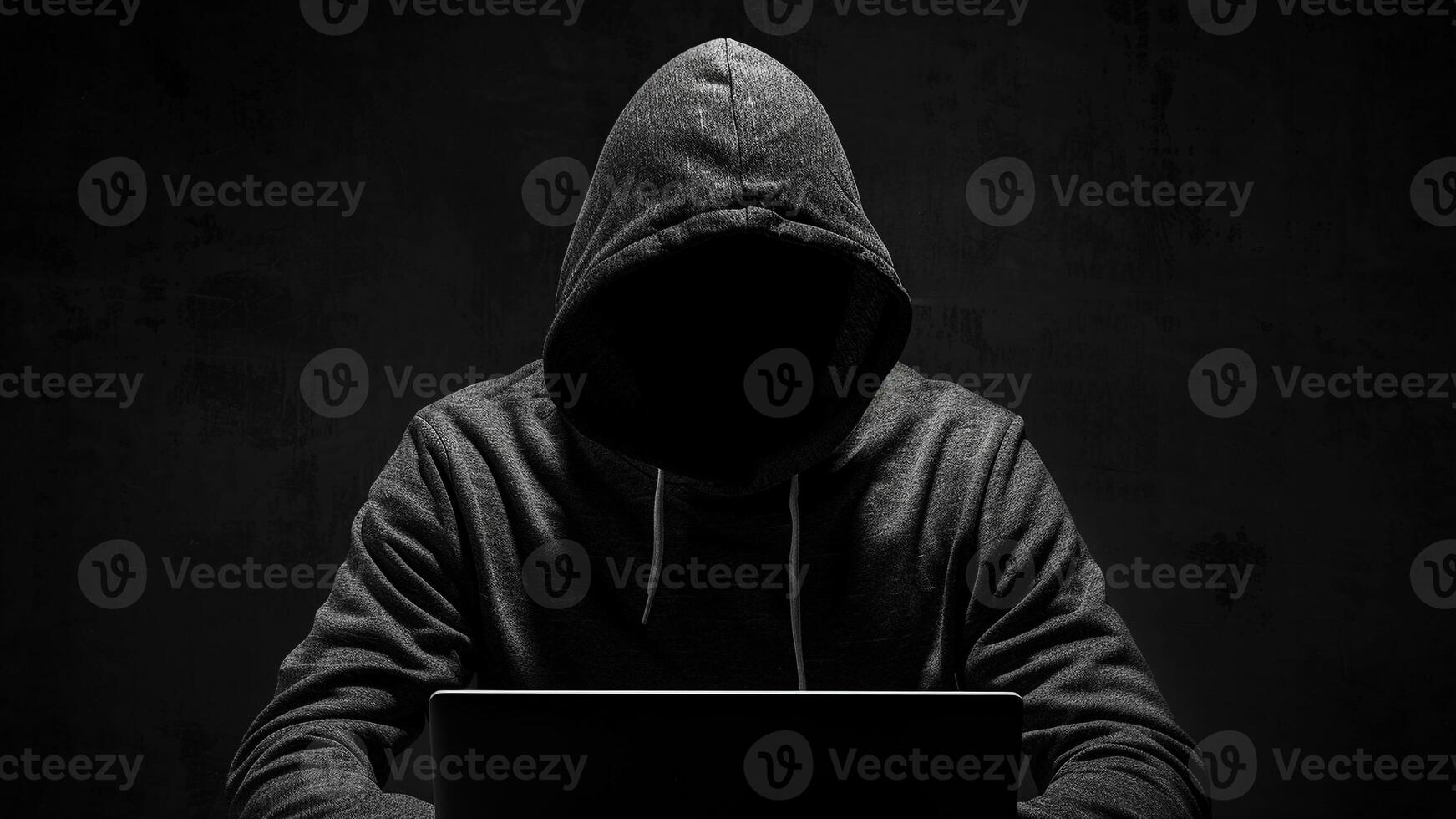 hacker with laptop computer on dark background photo