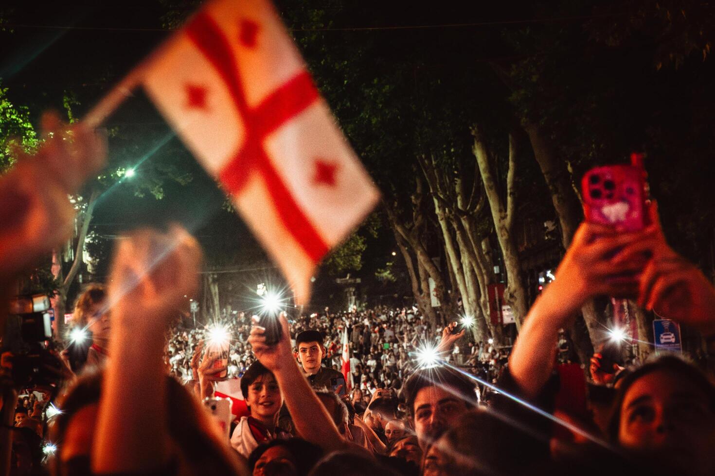 Tbilisi, Georgia - 2nd july, 2024- georgian football fans in streets wave flags. Georgian national football team arrival home welcome celebrations in capital city Tbilisi streets. photo