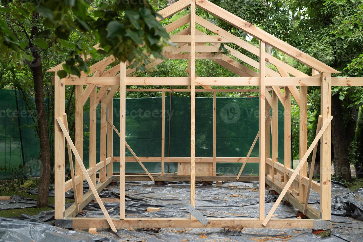 Construction of a large wood greenhouse in garden. Wooden domestic greenhouse for growing vegetables or flowers. photo