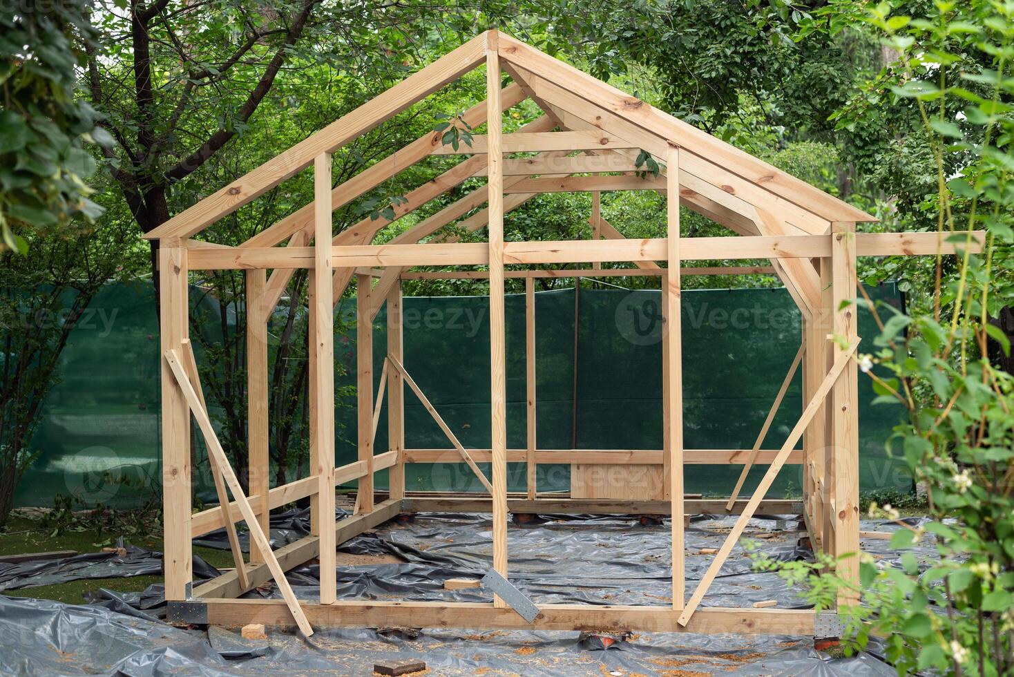 Construction of a large wood greenhouse in garden. Wooden domestic greenhouse for growing vegetables or flowers. photo