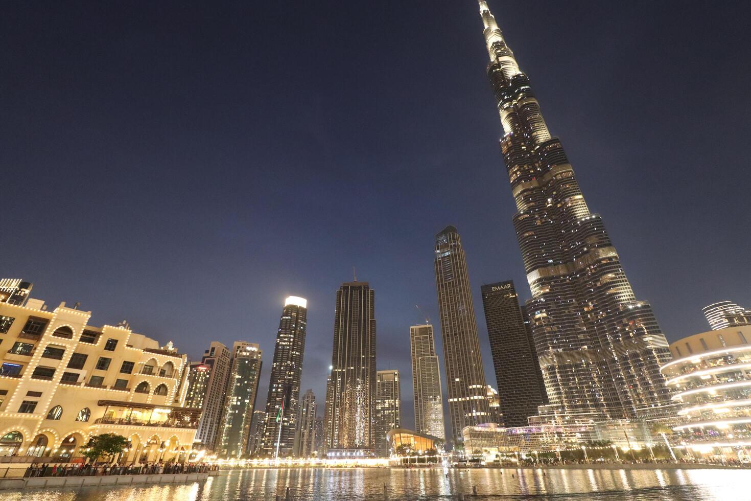 uae, dubai , 1th December 2022 a picture of the burj khalifa with towers and buildings in the night with small lake photo
