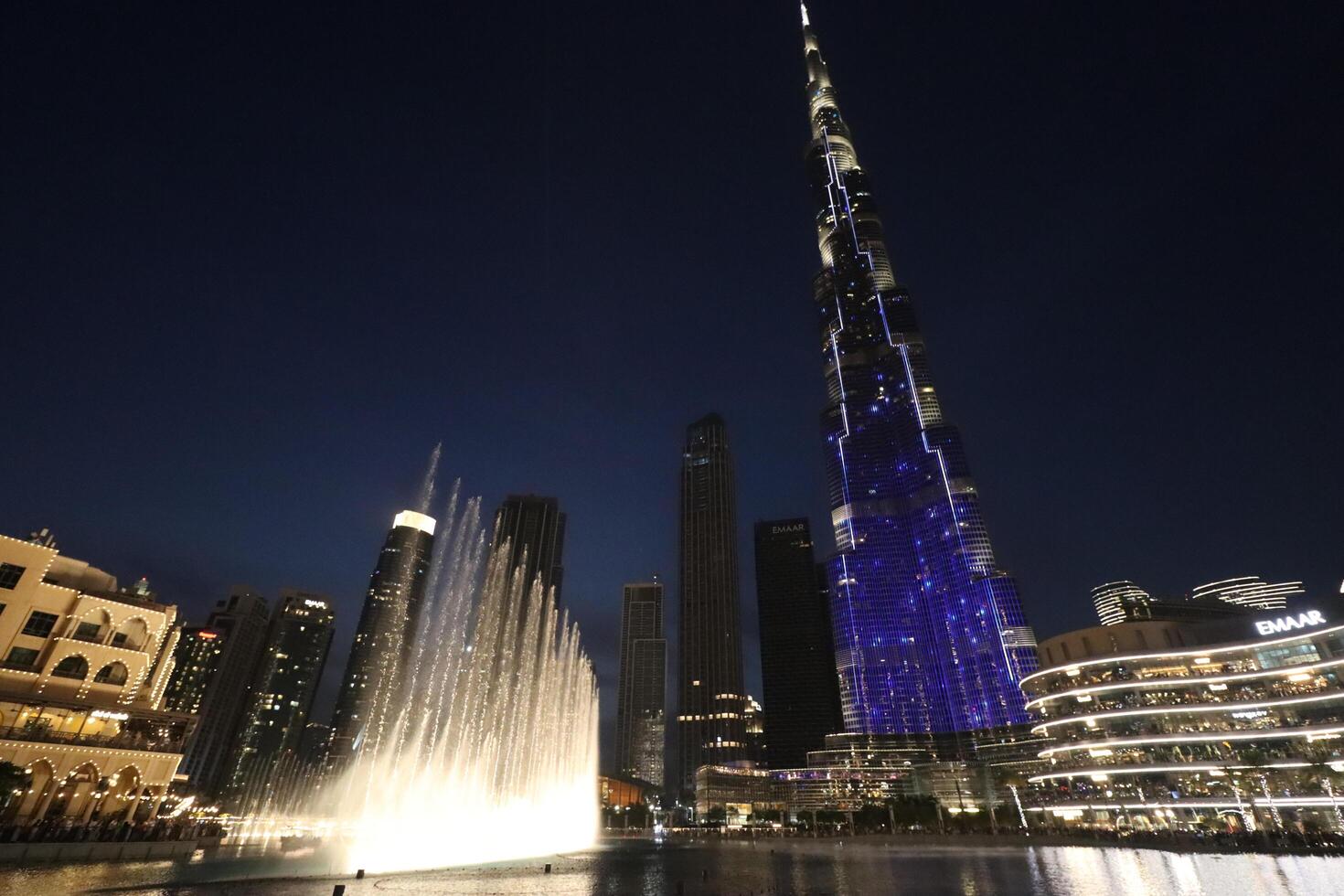 uae, dubai , 1th December 2022 a picture of the burj khalifa with towers and buildings in the night with small lake photo