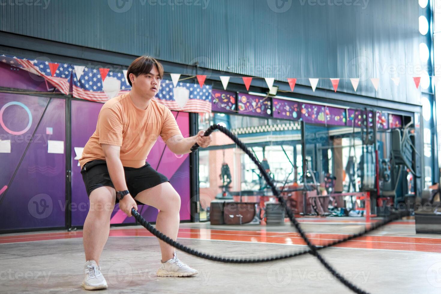 An overweight man is holding a rope and appears to be exercising photo