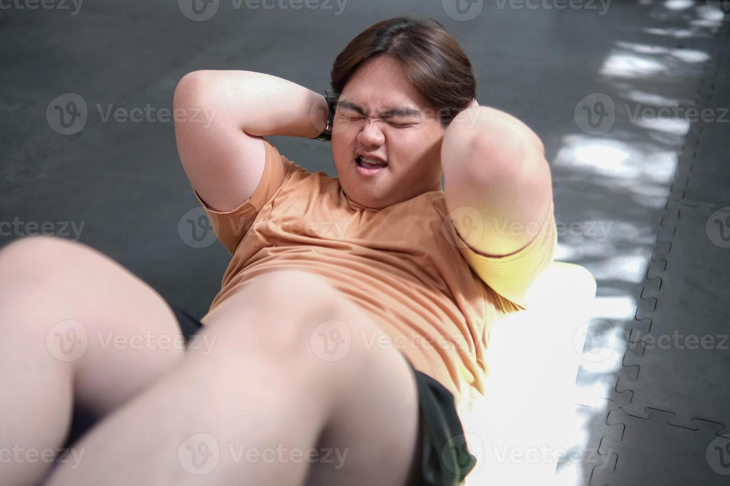 Overweight man doing crunches on exercise mat photo