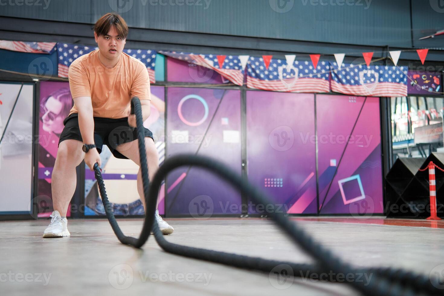 An overweight man is holding a rope and appears to be exercising photo