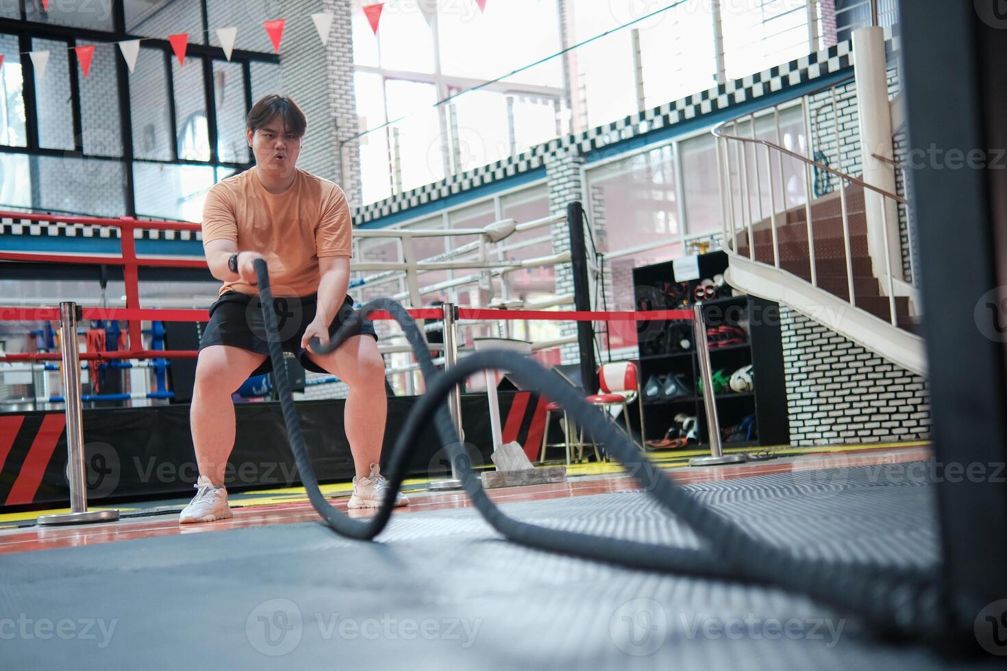 An overweight man is holding a rope and appears to be exercising photo
