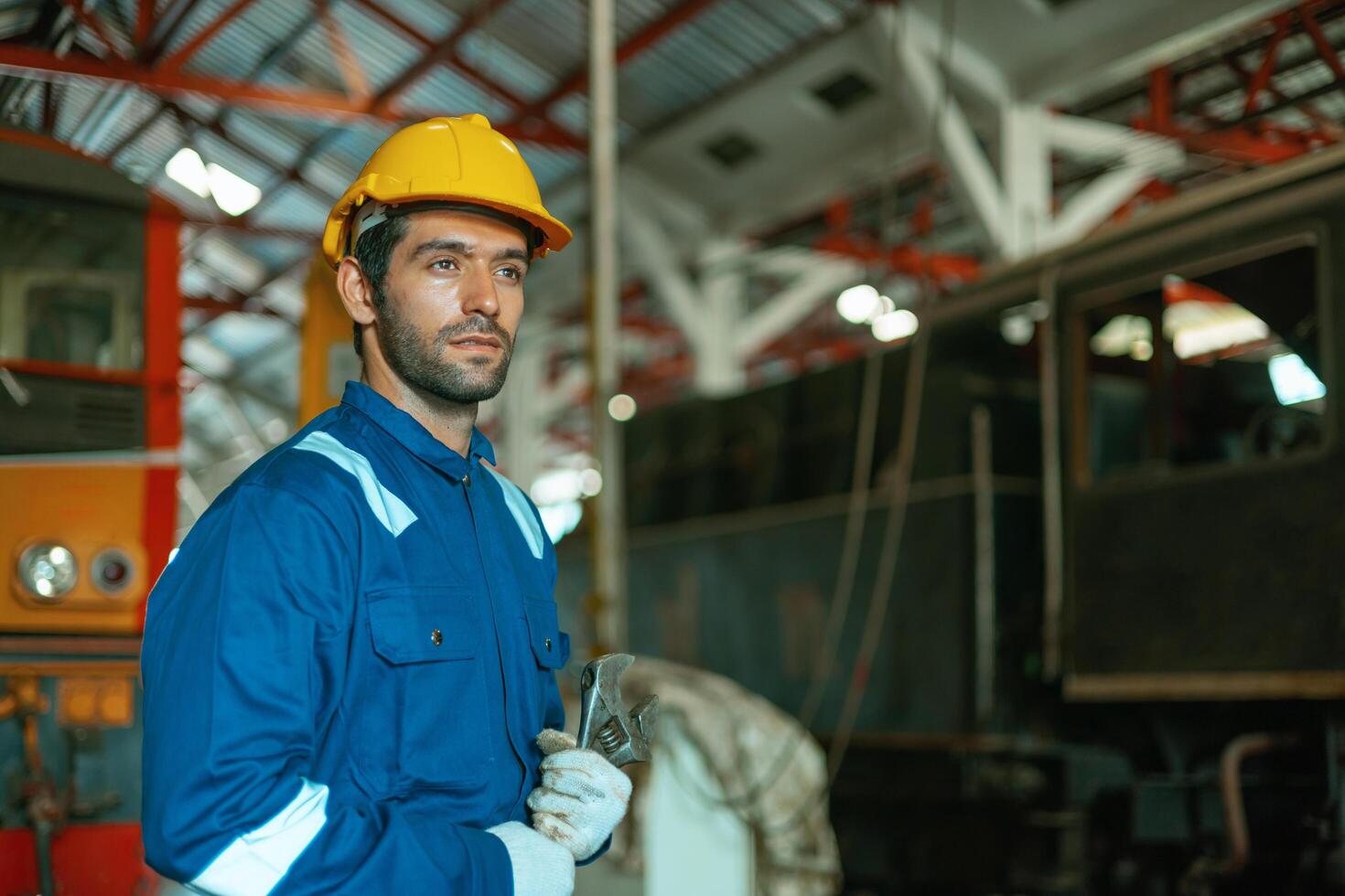 man in a blue and white uniform is standing in a train station photo