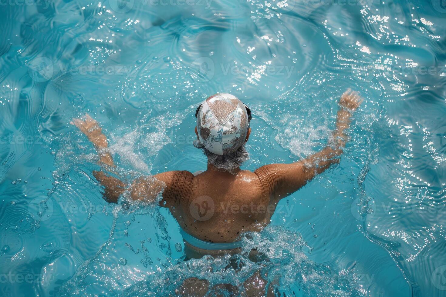 Aerial view of a woman with a swim cap swimming in the crystal clear water of a pool photo