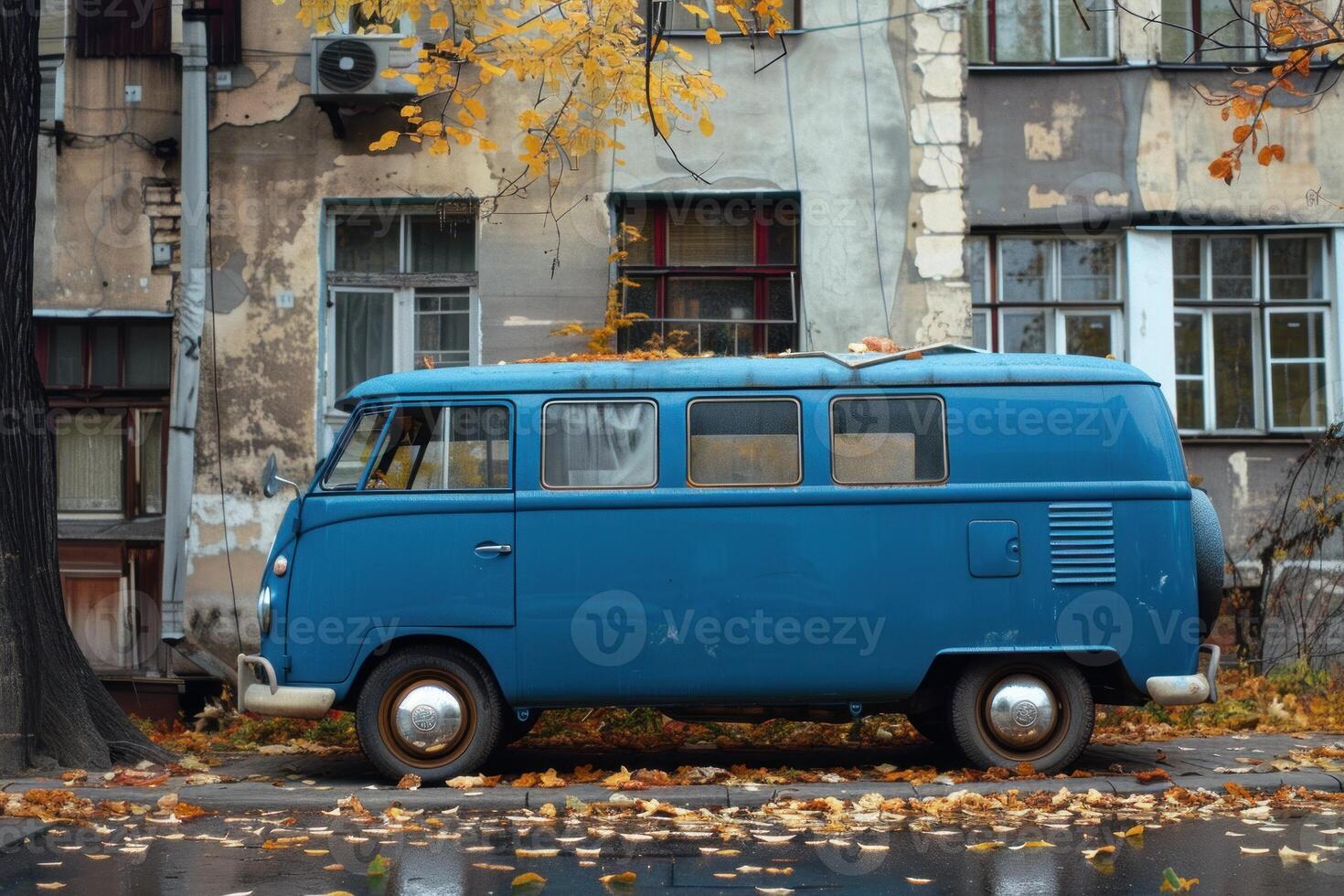 Old blue van parked on a street in autumn photo