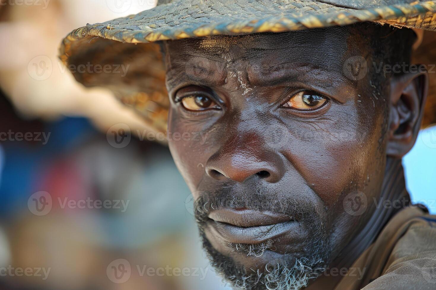 Intense gaze of an african man in a straw hat photo