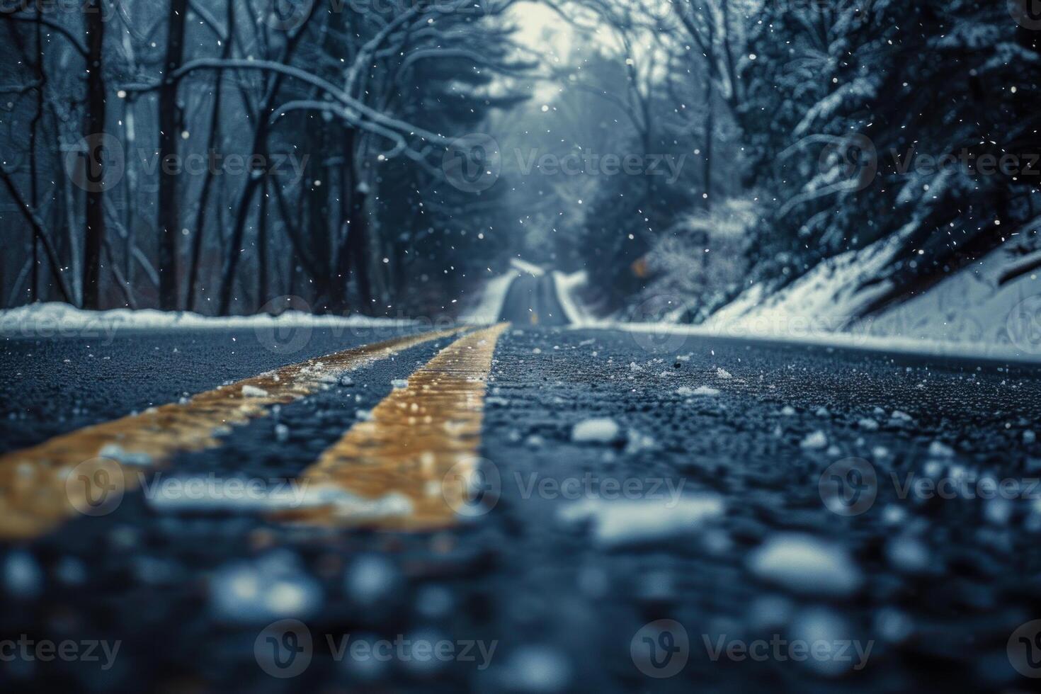 Closeup view of a snowy road with blurred trees and falling snowflakes photo