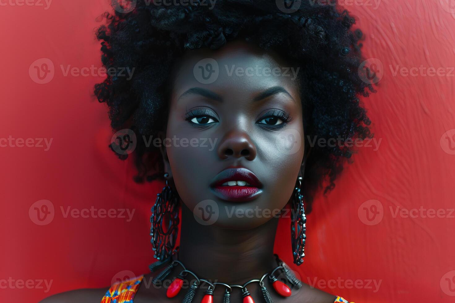 Beautiful black woman with afro hair posing on red background photo
