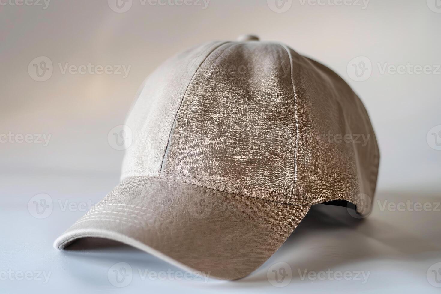 Close up of a beige baseball cap lying on a white surface with a shallow depth of field photo