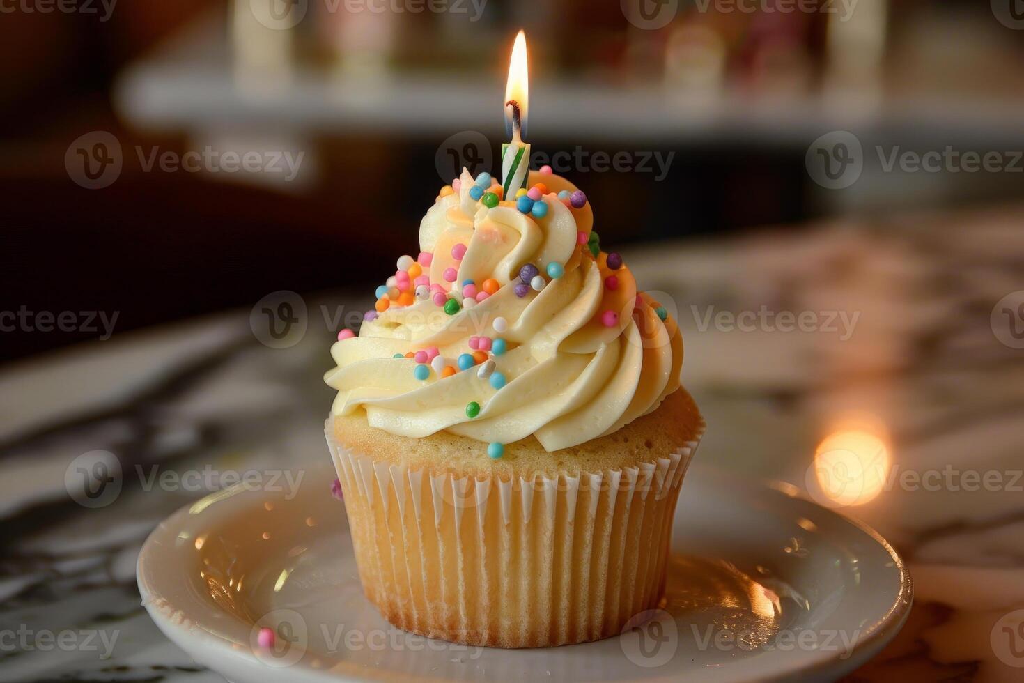 Single cupcake with lit candle is sitting on white plate and celebrating birthday photo