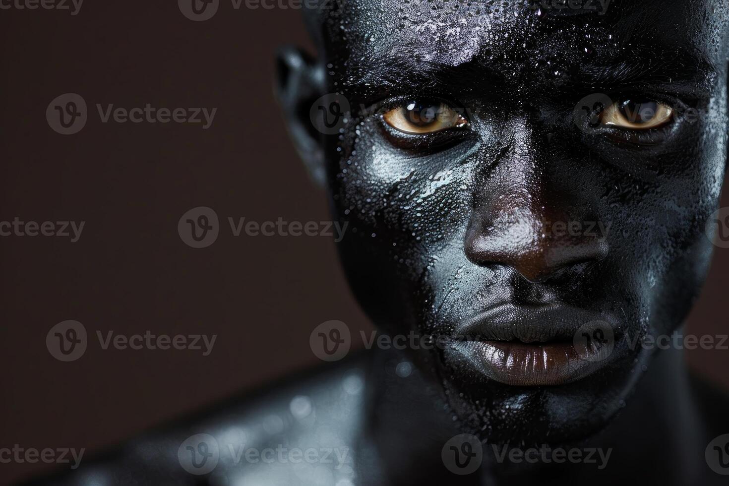 Close up portrait of a man with black and wet skin posing in a studio photo