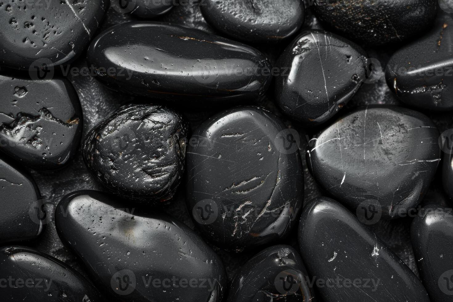 Polished black tourmaline minerals are arranged showing texture and natural patterns photo