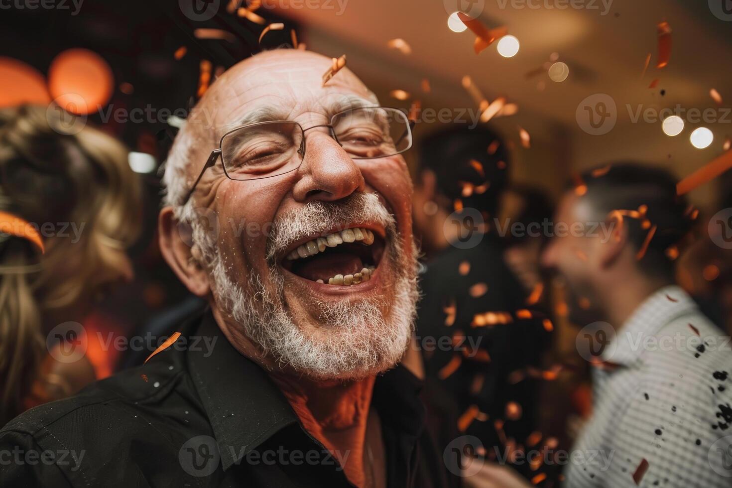 Senior man laughing with falling confetti at party photo
